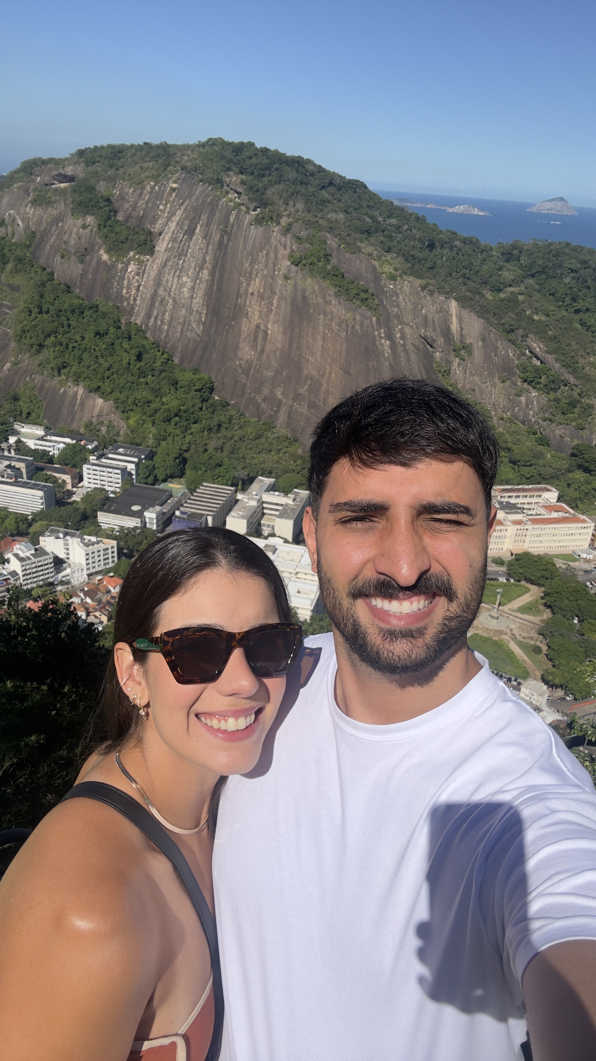 Nós dois no alto do morro, com o mar do Rio ao fundo